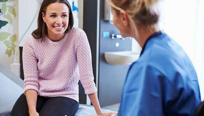 Female Patient And Nurse Have Consultation In Hospital Room