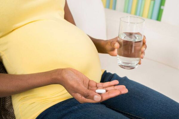 Pregnant Woman Taking Medicine At Home