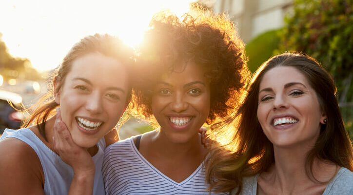 Portrait of three young adult female friends in the street