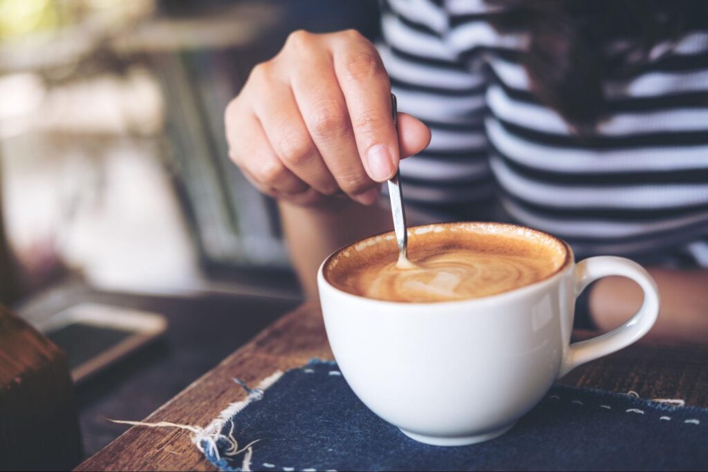 Someone stirring a cup of coffee
