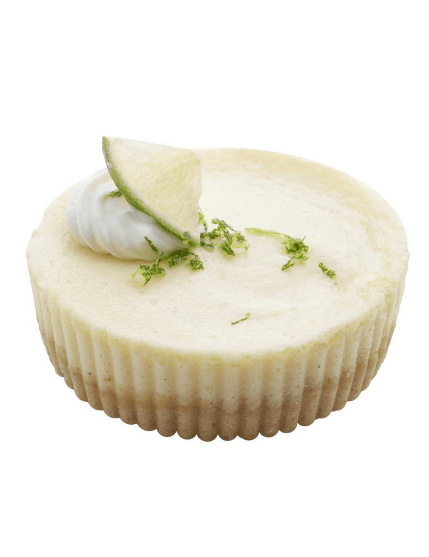 Lime cheesecake garnished with whipped cream, lime zest, and a candied lime slice on a ridged cookie crust.