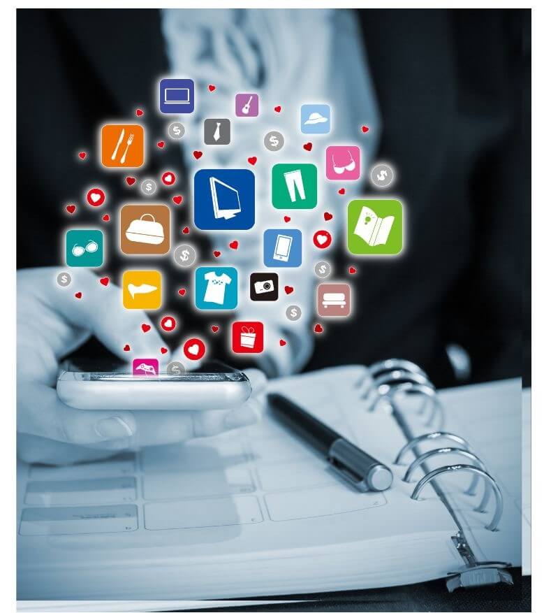 A person is holding a smartphone while various colorful app icons and symbols float above it, set against a blurred notebook background.