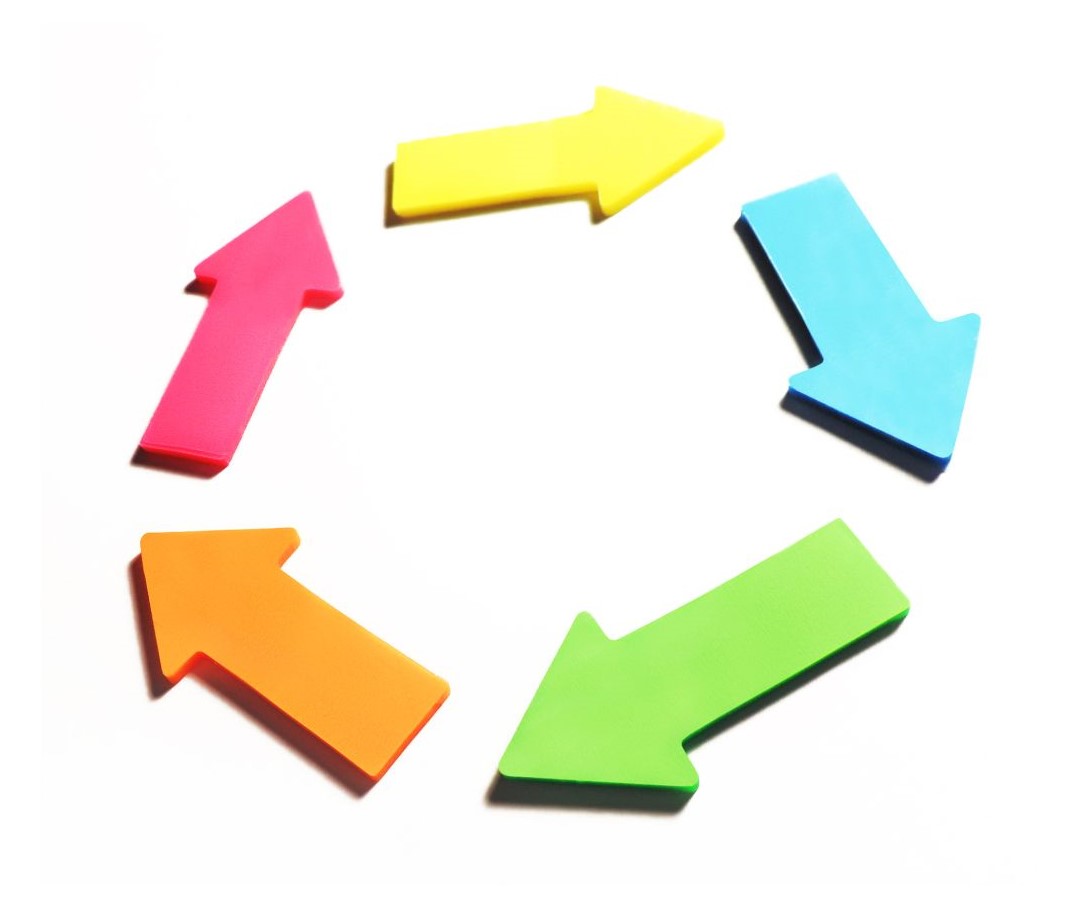 Colorful plastic arrows in a circular arrangement point in various directions.