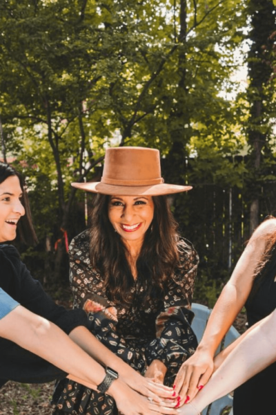 hol+ circle members with hands in center celebrating their community