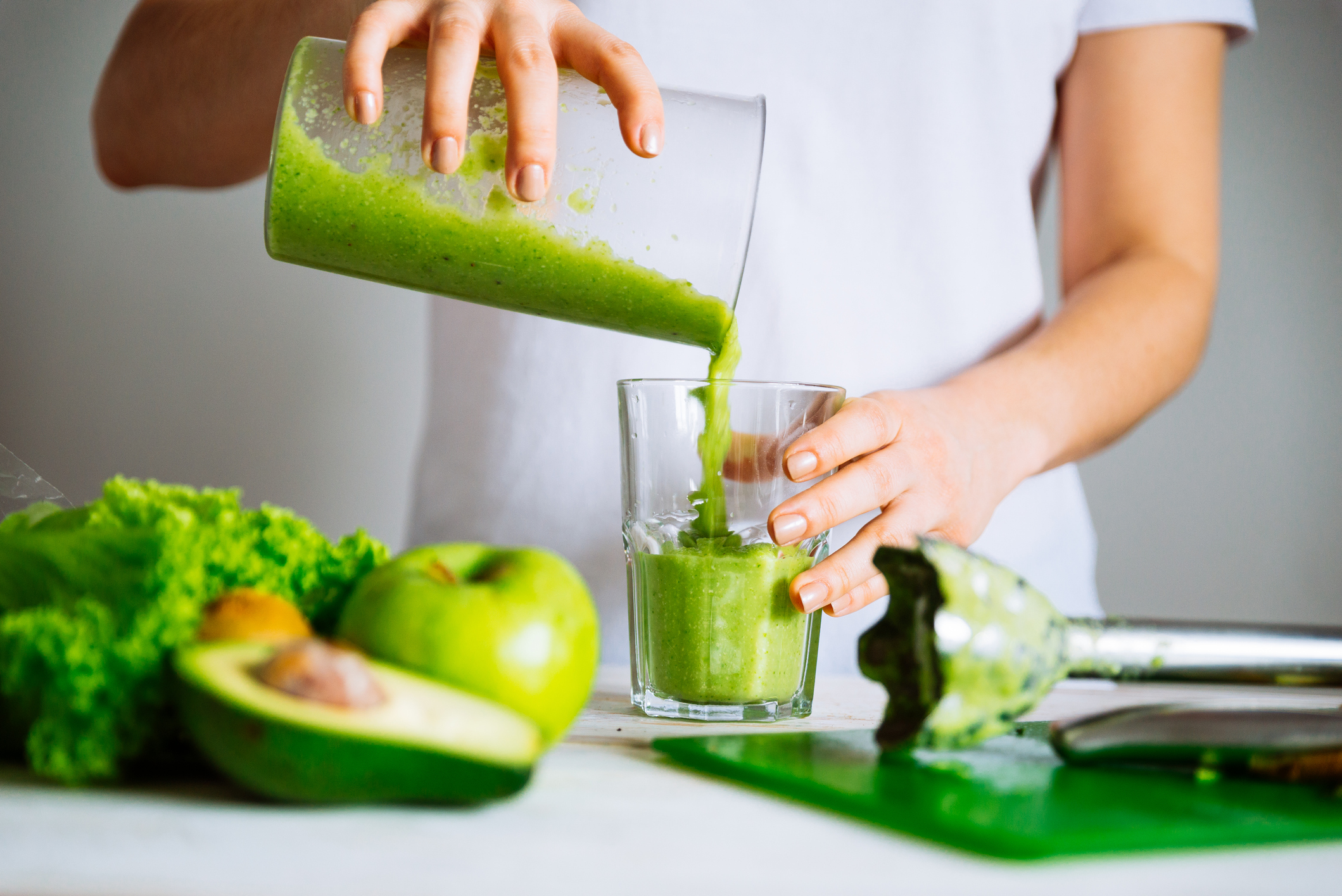 Green smoothie being poured into glass