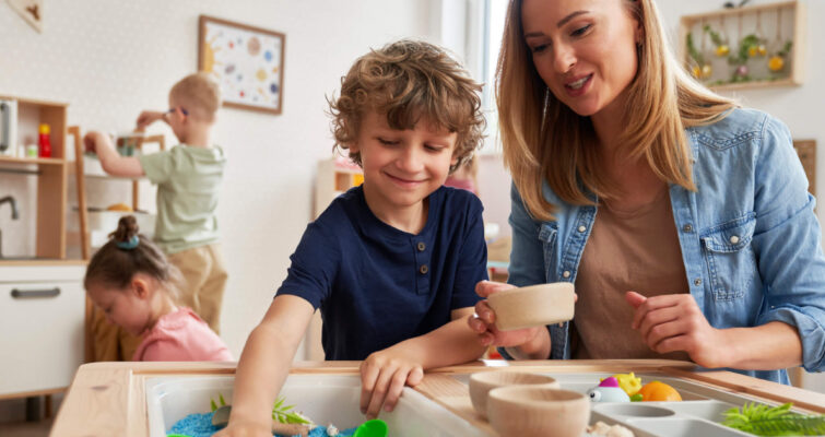 A woman and child joyfully play together at a wooden table, highlighting a nurturing interaction in a home setting.