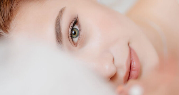 A woman in a wedding dress gazes directly at the camera with a joyful expression.