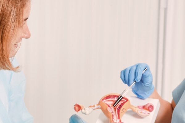 A woman holds a toothbrush while another woman observes her intently.