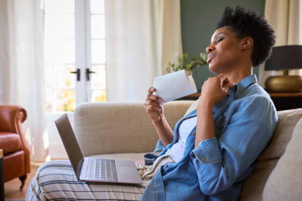 A woman using a laptop and credit card, exploring personalized hormone therapy options for menopause and beyond.