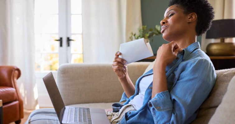 A woman using a laptop and credit card, exploring personalized hormone therapy options for menopause and beyond.