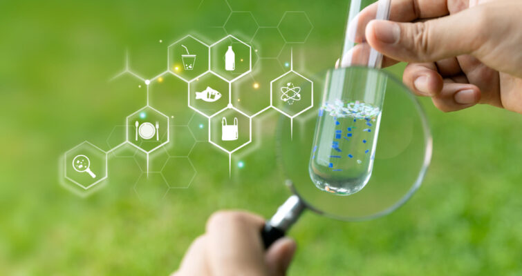 A hand holds a test tube containing a chemical substance, with scientific icons in the background.