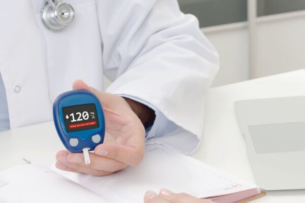 A doctor holds a blood glucose meter, emphasizing diabetes management in Atlanta's healthcare landscape.