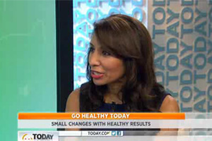 A woman speaking on the news about the benefits of healthy foods and nutrition for a balanced lifestyle.