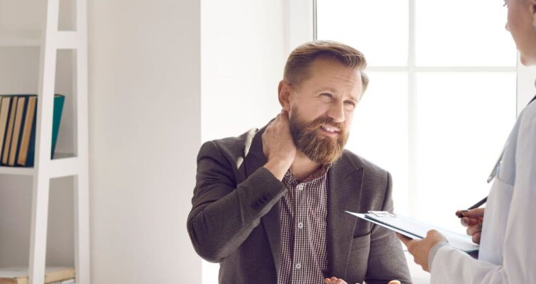 A woman consults with a man in a doctor's office, representing holistic health practitioners in Atlanta.