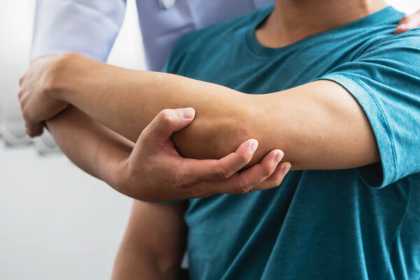 A man receives an arm examination from a doctor for chronic joint pain.