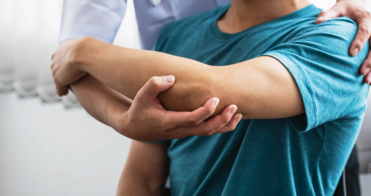 A man receives an arm examination from a doctor for chronic joint pain.