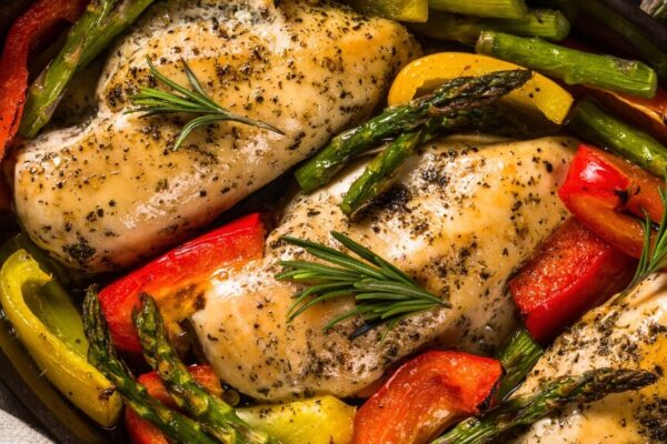 Chicken breast sautéed with colorful vegetables and herbs in a pan, showcasing a healthy keto meal option.