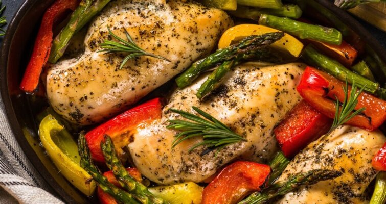 Chicken breast sautéed with colorful vegetables and herbs in a pan, showcasing a healthy keto meal option.
