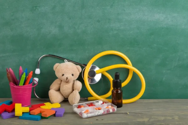 A teddy bear and a stethoscope on a table, symbolizing care and awareness for PANS/PANDAS in children.