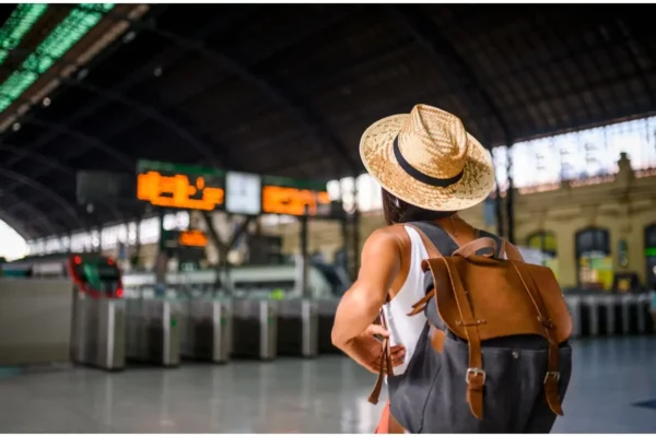A traveler with a backpack walking on a trail, symbolizing tips for comfortable travel and avoiding digestive issues.