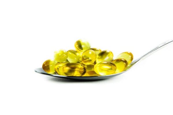 Fish oil capsules arranged on a spoon, featured in a guide for weight loss supplements for holiday detox.