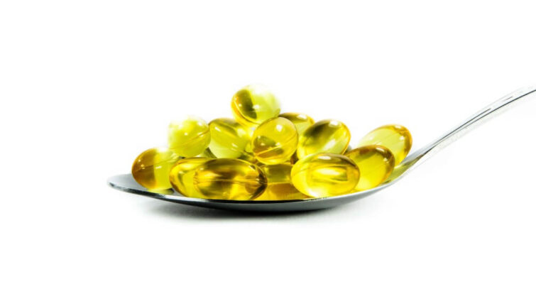 Fish oil capsules arranged on a spoon, featured in a guide for weight loss supplements for holiday detox.