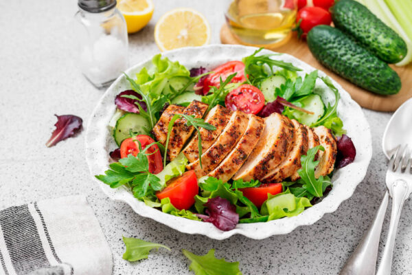 Grilled chicken breast served with a fresh salad on a plate, highlighting brain-boosting foods for ADHD.