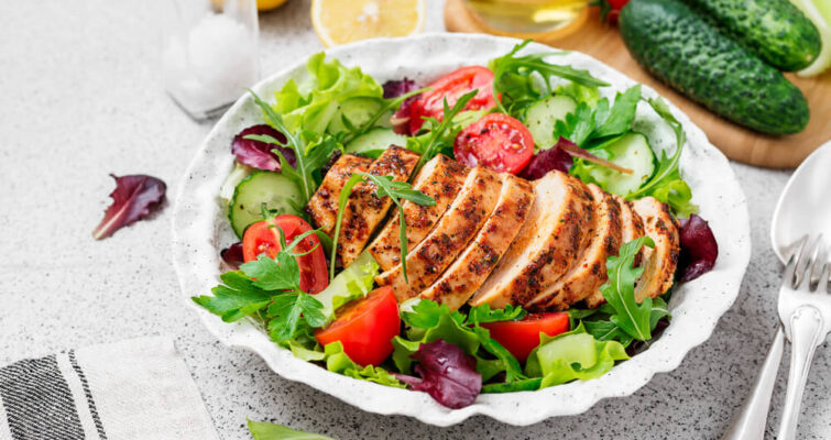 Grilled chicken breast served with a fresh salad on a plate, highlighting brain-boosting foods for ADHD.