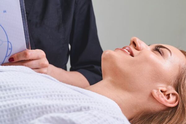 A woman receives a facial treatment in a serene room, highlighting the practice of Face Mapping in Chinese Medicine.