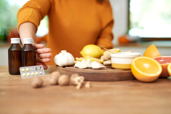 A woman holds a bottle of essential oils, highlighting natural remedies like quercetin and other antihistamines.