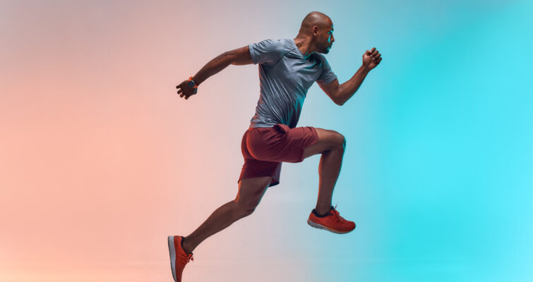 A man in a running pose against a vibrant background, symbolizing energy and vitality related to low testosterone treatment.