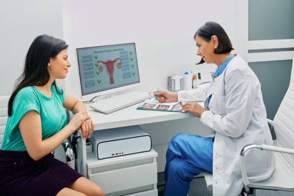 A woman consults a doctor in an office, discussing potential misdiagnosed illnesses.