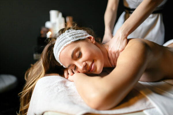 A woman receiving a relaxing back massage at a spa, highlighting the benefits of Tui Na massage therapy.