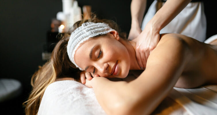 A woman receiving a relaxing back massage at a spa, highlighting the benefits of Tui Na massage therapy.