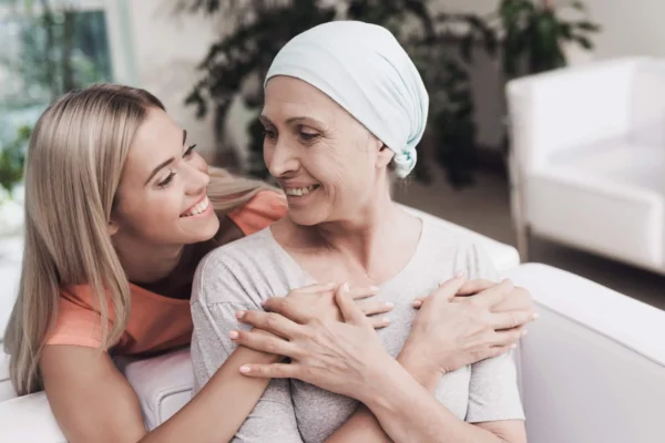 young girl supporting an older lady during her cancer support