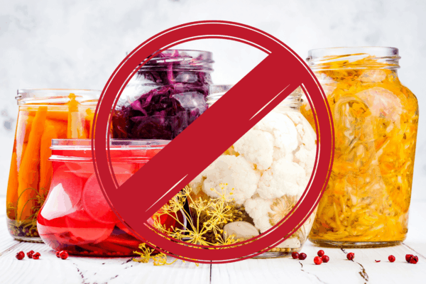 A collection of jars filled with various vegetables and foods, related to the topic of dysbiosis and digestive health.
