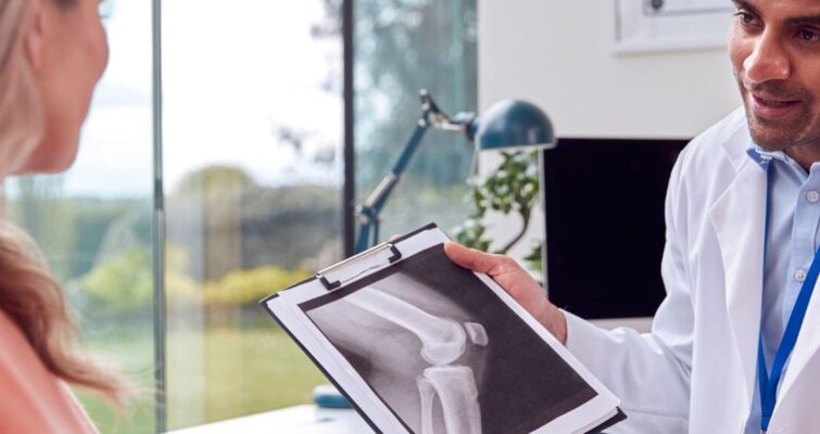 A man holds an X-ray image of a woman, illustrating the 4 stages of osteoporosis.