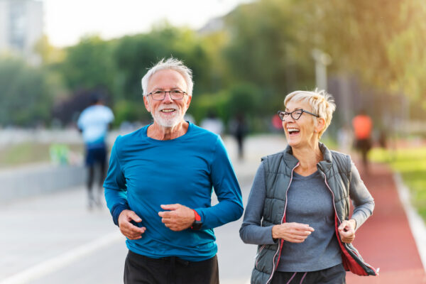 Older couple smiling while jogging