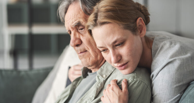 Daughter comforting father with Alzheimer's Disease