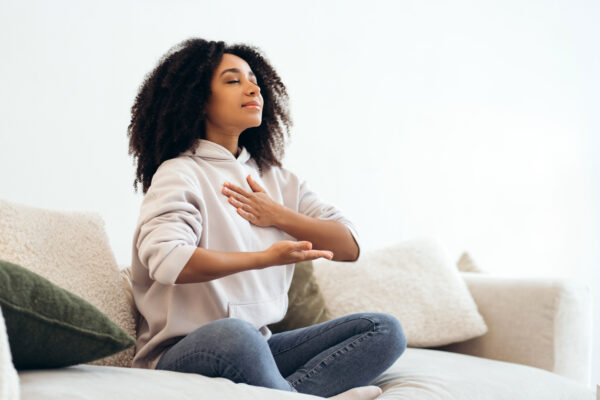 Serene young woman practicing breathing exercises