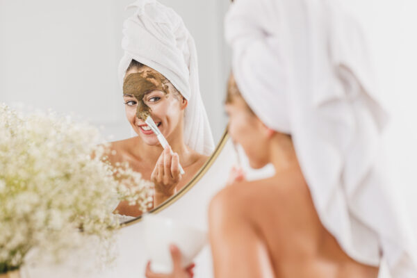 Woman in front of mirror applying algae skincare
