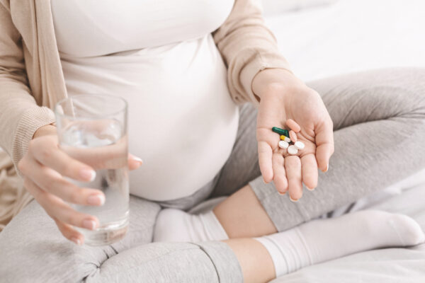 Expectant woman holding prenatal supplements