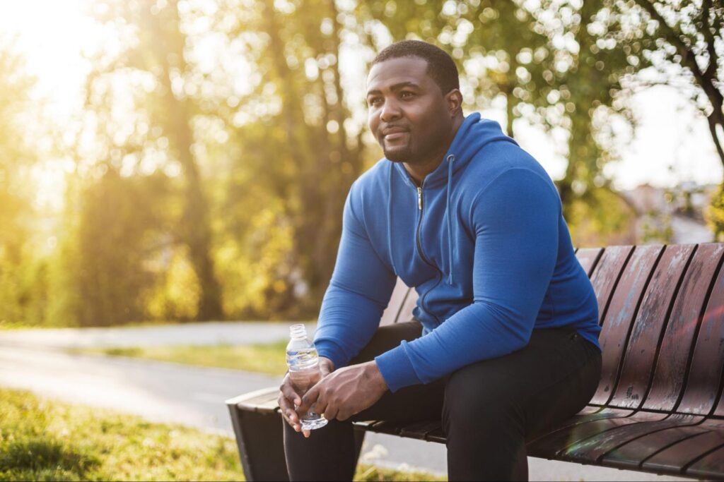 A man sitting on a park bench after exercising
