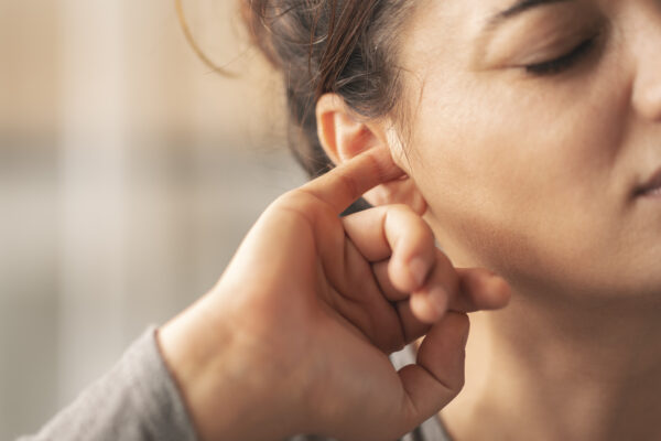 Woman in perimenopause itching her ears.