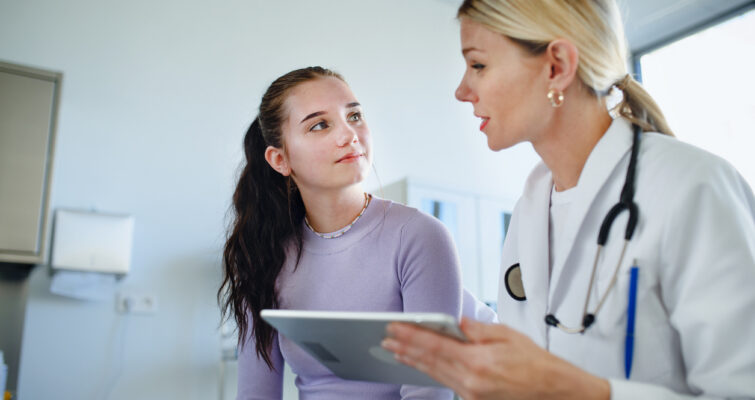 Doctor explaining diagnosis to teenage girl