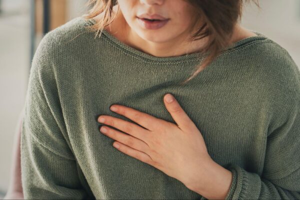 A woman holding her upper chest