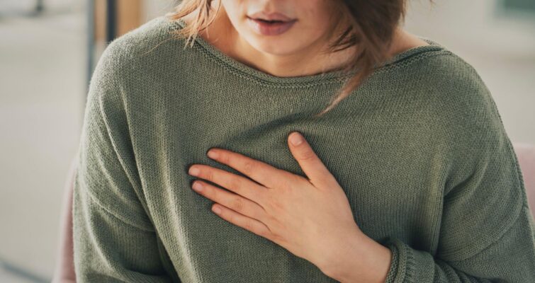 A woman holding her upper chest